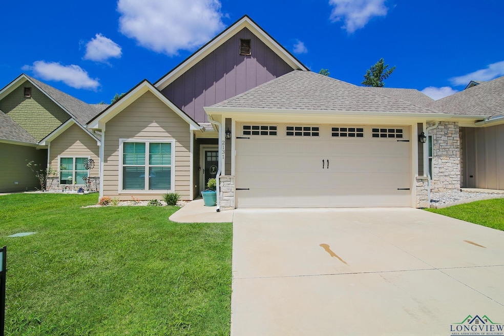 View of front of property featuring board and batten siding, an attached garage, stone siding, a front lawn, and concrete driveway