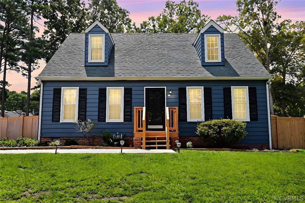 Cape cod-style house featuring a lawn