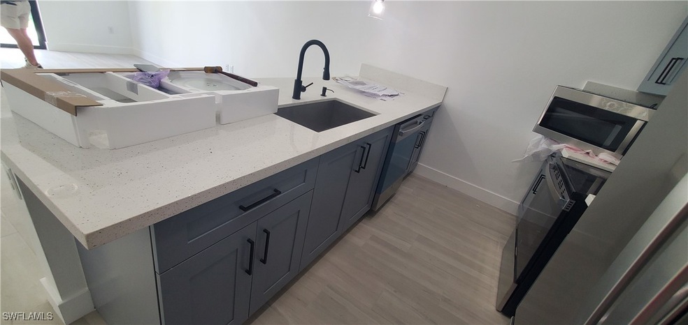Kitchen with light stone countertops, baseboards,