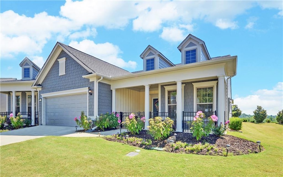 View of front of home with a porch, a garage, and 