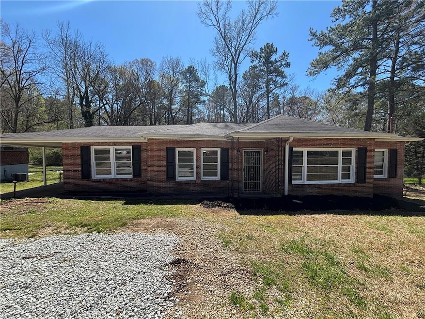 Ranch-style home with a carport, brick siding, and
