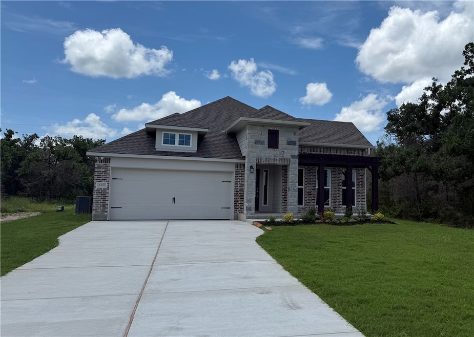 View of front facade with stone siding, driveway,