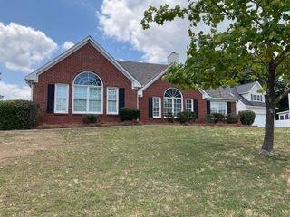 Single story home featuring a front lawn