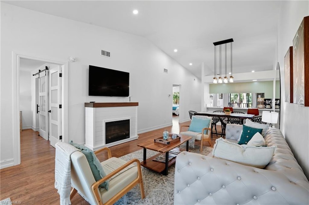 Light-filled open living space with wide windows overlooking lush greenery, perfect for relaxing or working from home.