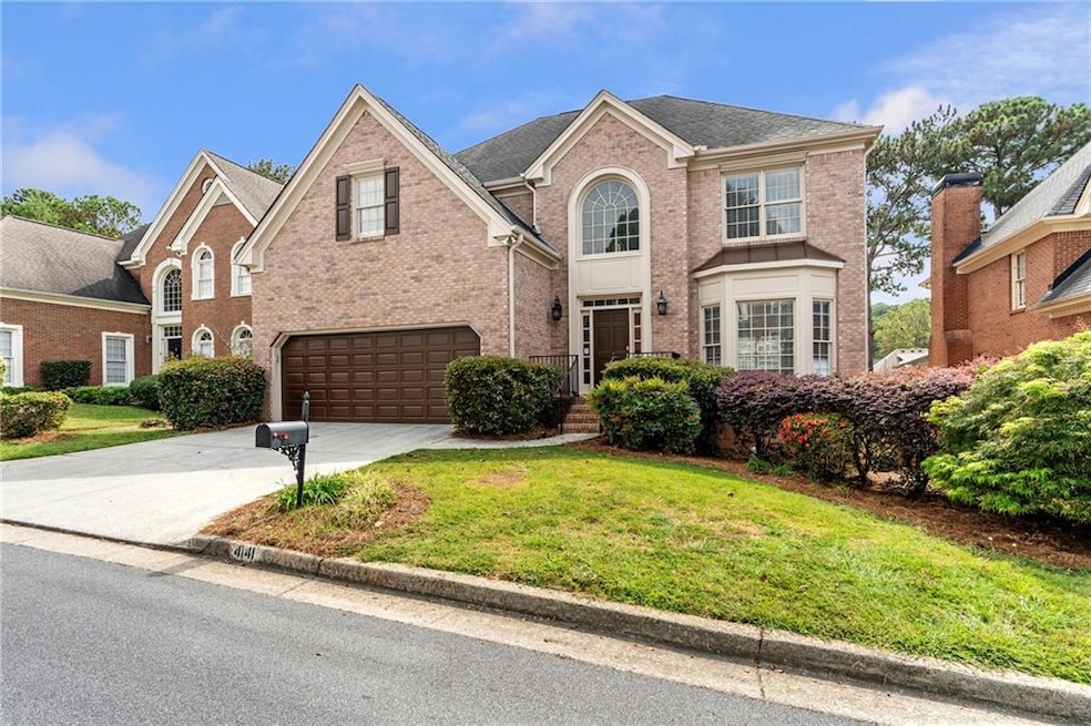 Traditional home with brick siding, driveway, a front yard, an attached garage, and a shingled roof