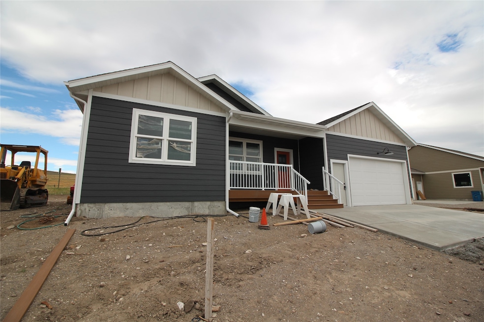 Ranch-style house featuring a porch, driveway, and a garage
