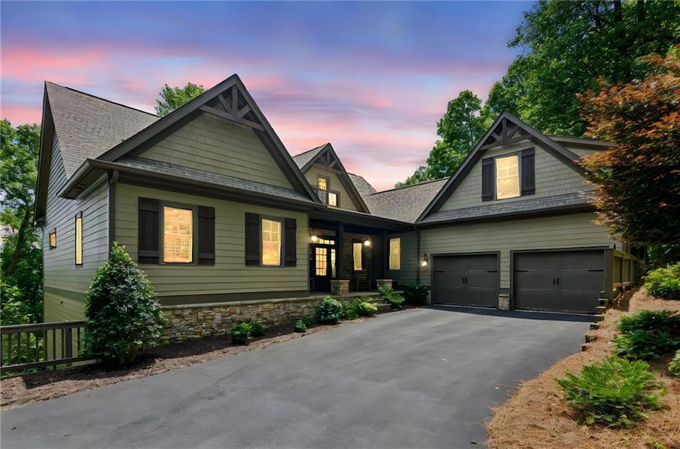 Craftsman-style home featuring driveway, a porch, stone siding, an attached garage, and roof with shingles
