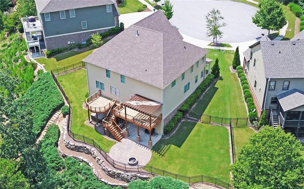 Aerial view of the home showing the decks, fire pit, stone wall and fencing.