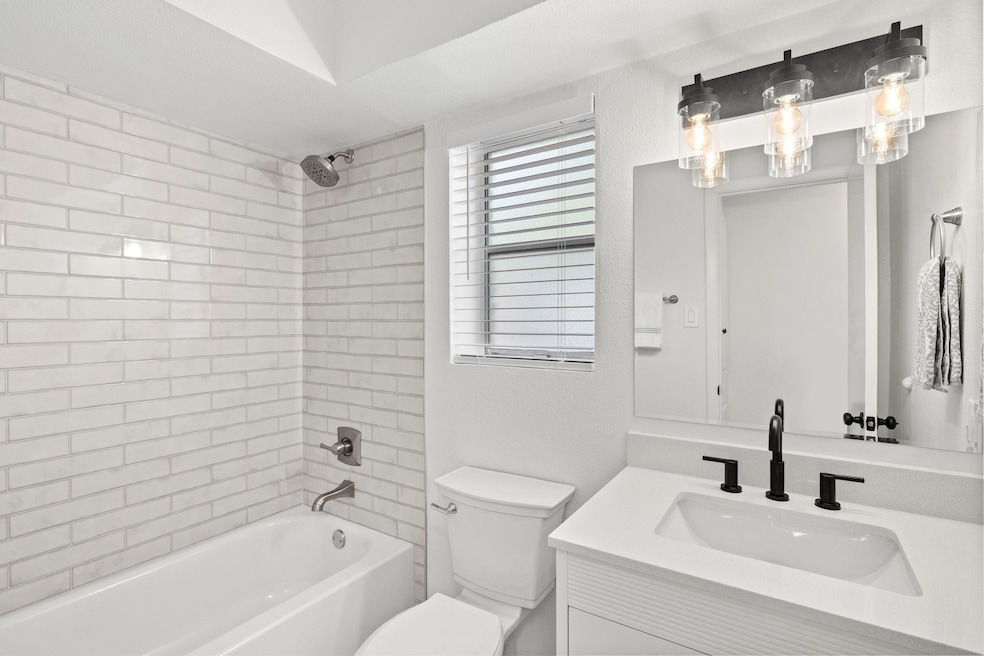 Bathroom featuring vanity, toilet, and washtub / 