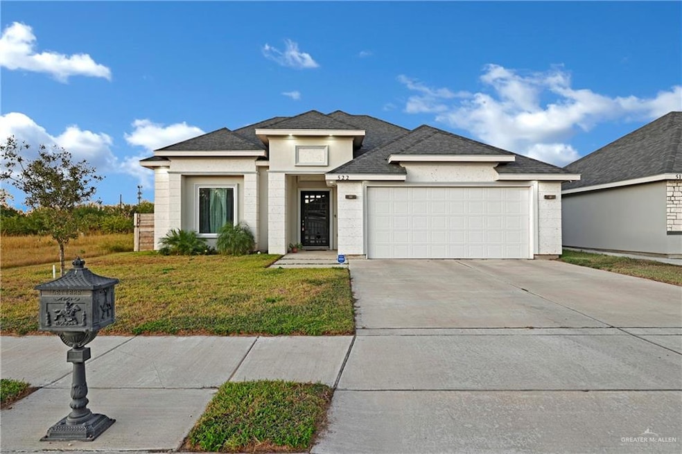 View of front of house featuring a garage and a front lawn