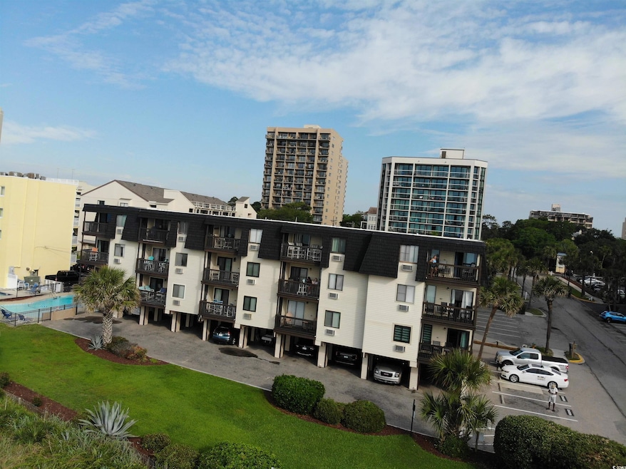 View of apartment building / complex featuring uncovered parking