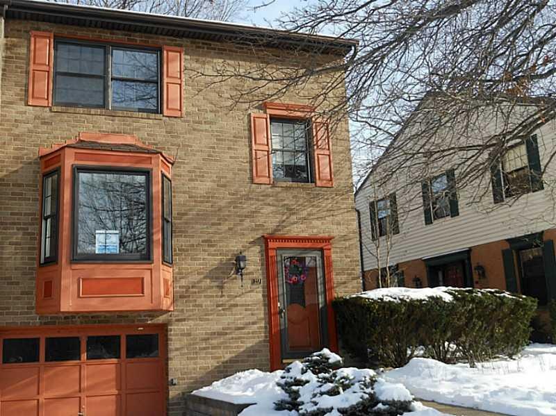 Exterior Front. Brick end unit condo with wooded r