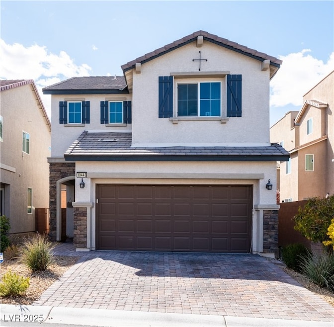 Traditional-style home with decorative driveway, a