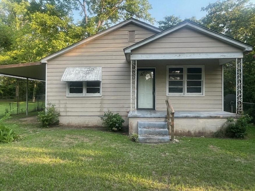 Bungalow with a carport and a front lawn