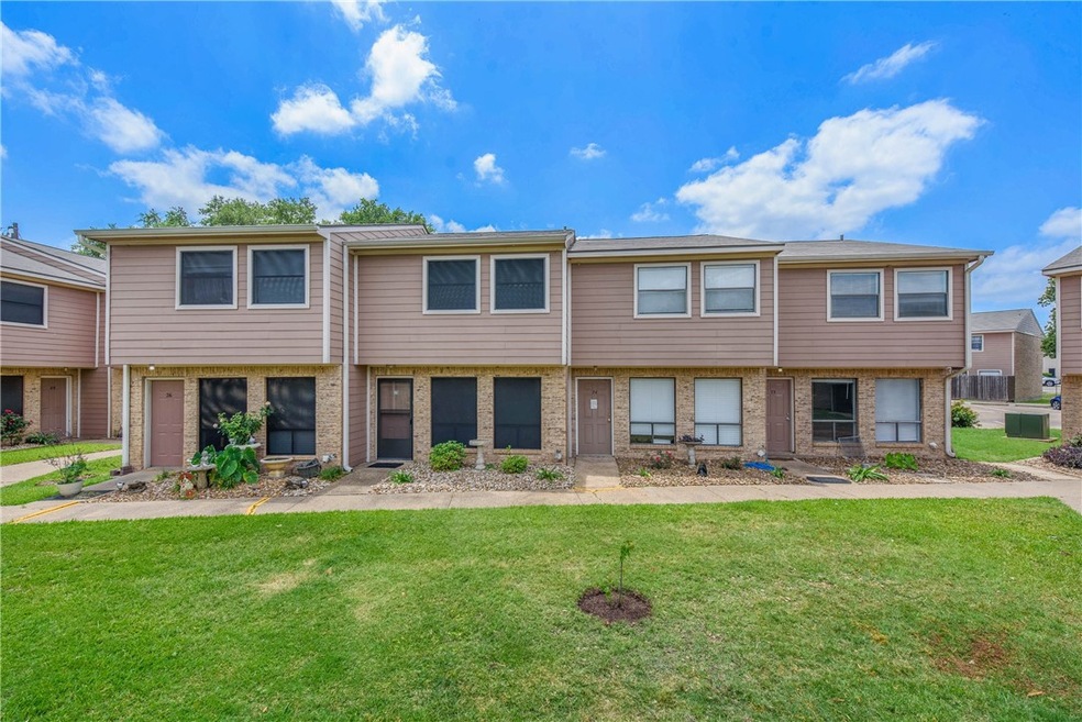 Multi unit property with a front yard and brick si