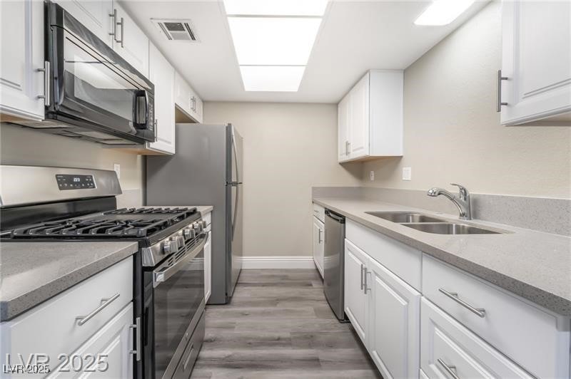 Kitchen featuring stainless steel appliances and white cabinetry