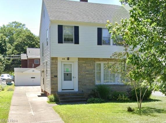 Colonial home featuring garage and a front lawn