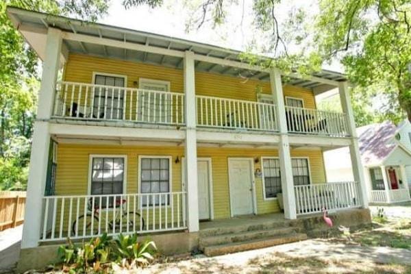 Back of house featuring a balcony and a porch