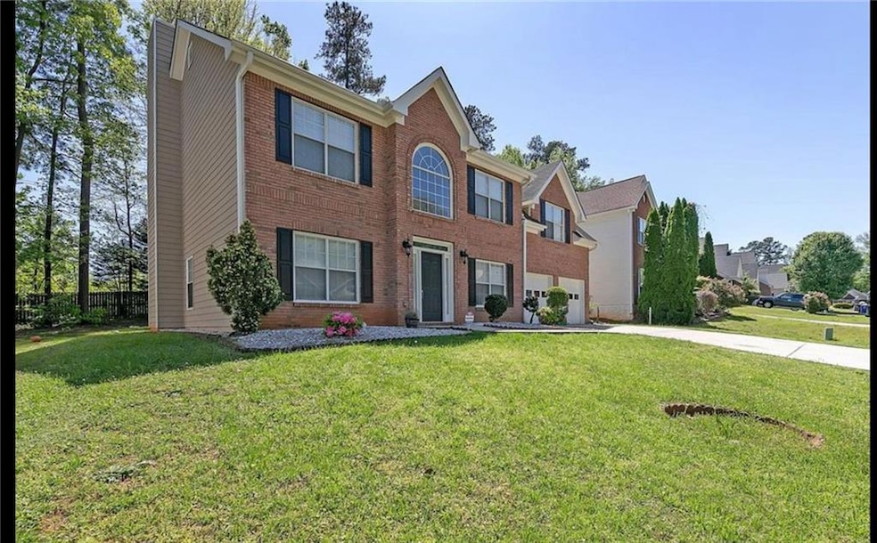Colonial home with concrete driveway and brick sid