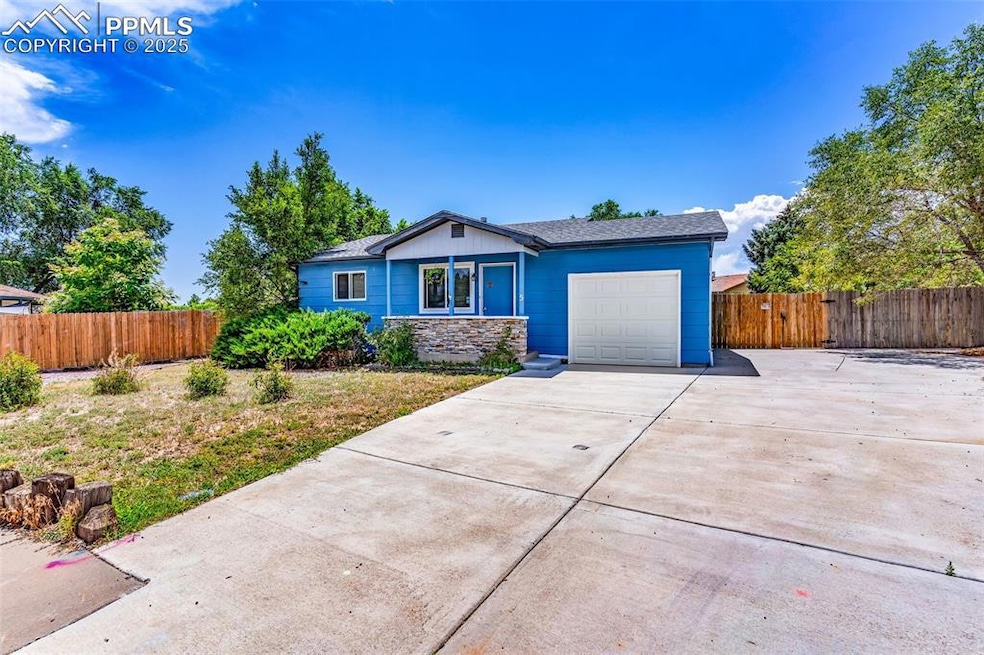 View of front of house with an attached garage, concrete driveway, and a shingled roof