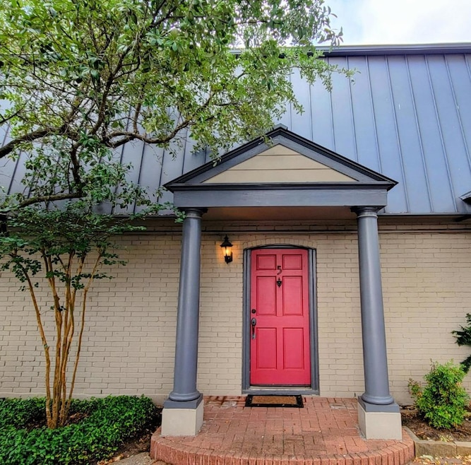 Property entrance featuring brick siding