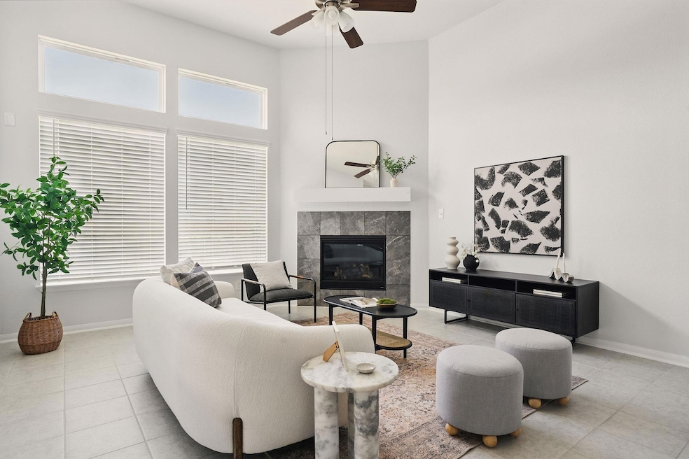 Tiled living area with a ceiling fan, a towering 