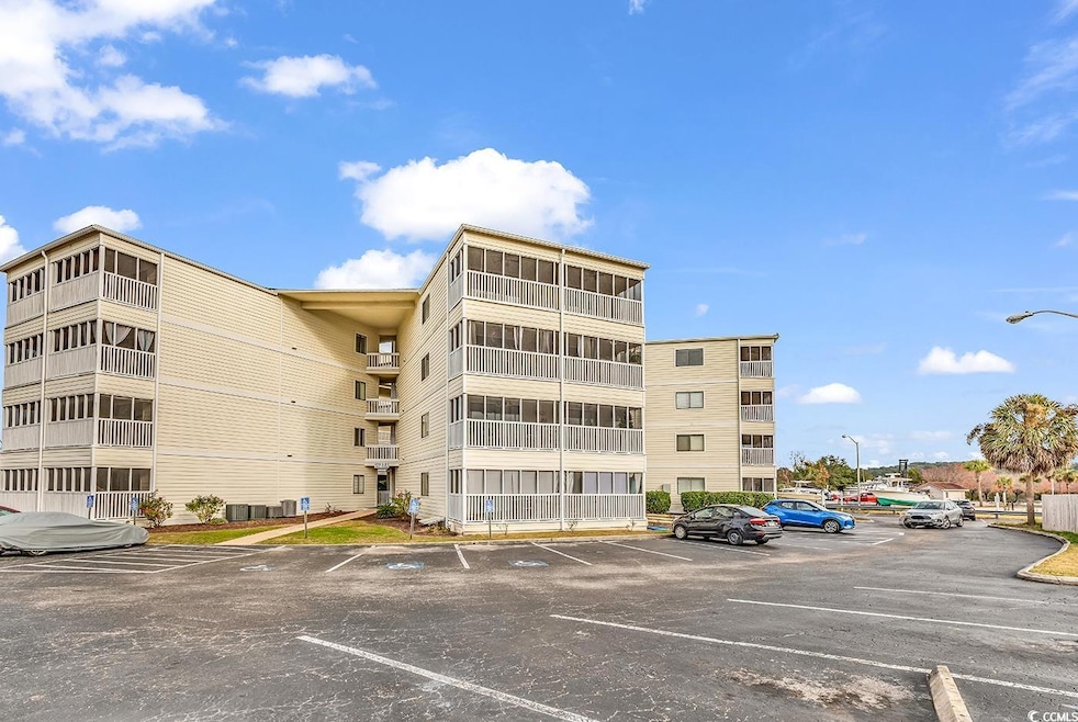 View of apartment building / complex featuring uncovered parking