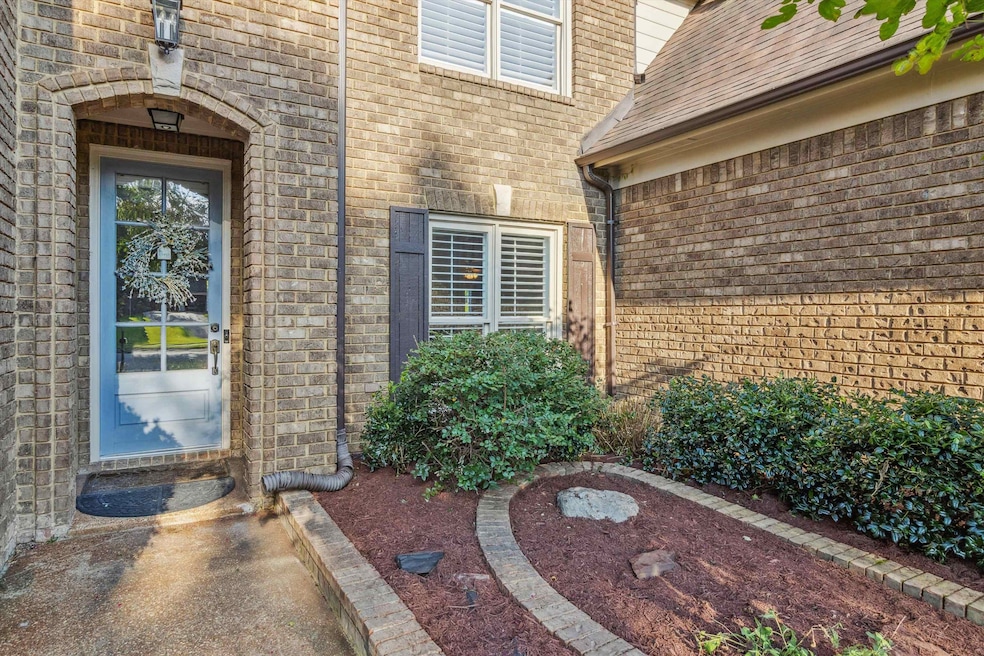 Property entrance featuring brick siding and roof with shingles