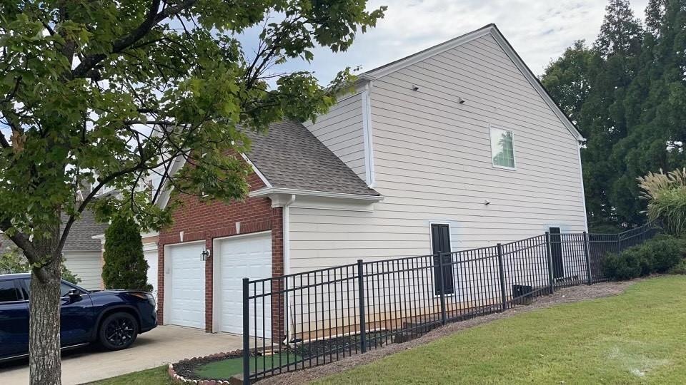 View of side of home with a garage and a lawn