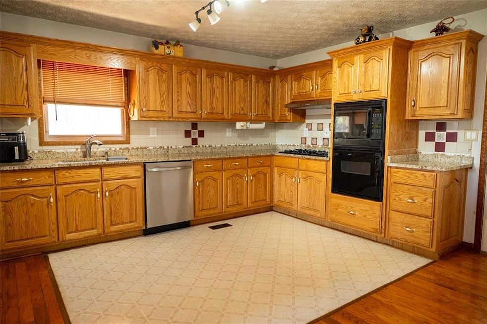 Kitchen with light wood-type flooring, backsplash,