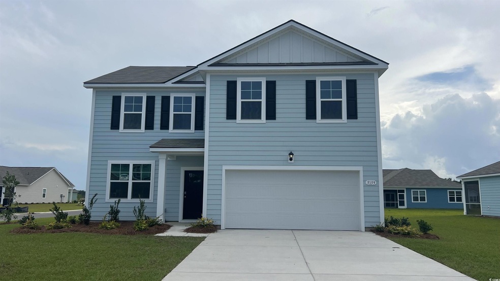 View of front of house with concrete driveway, a front yard, an attached garage, and board and batten siding