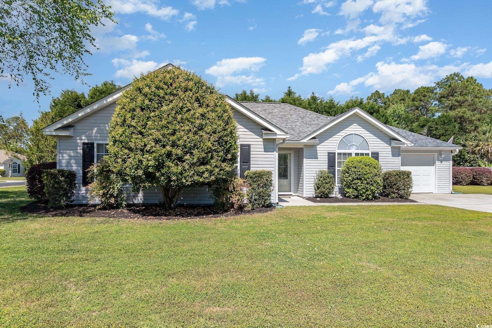Single story home featuring an attached garage, a shingled roof, driveway, and a front lawn