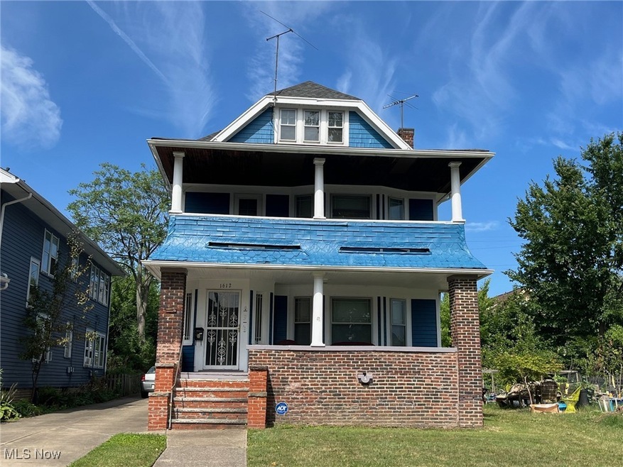View of front of home with a porch, a balcony, and a front yard
