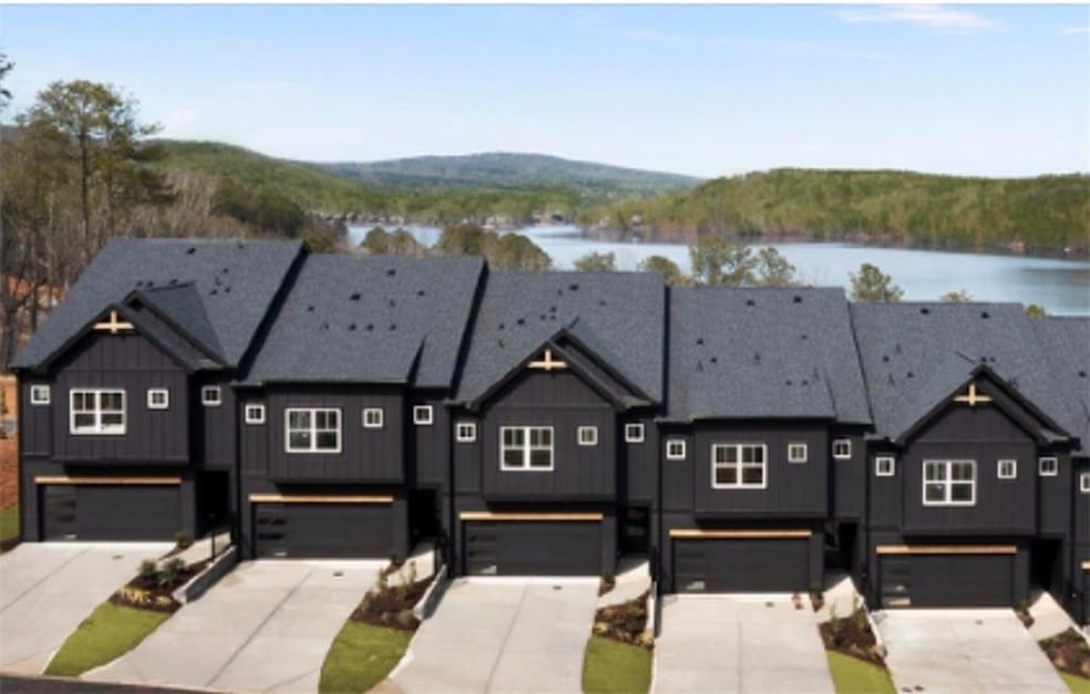 View of property with a water view, concrete drive