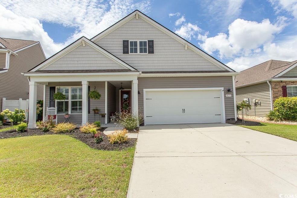 View of front facade featuring a porch, a garage, 