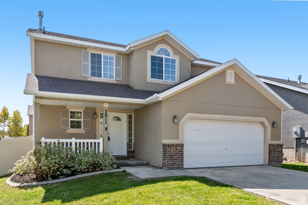 Traditional-style house featuring covered porch, stucco siding, concrete driveway, a shingled roof, and a garage