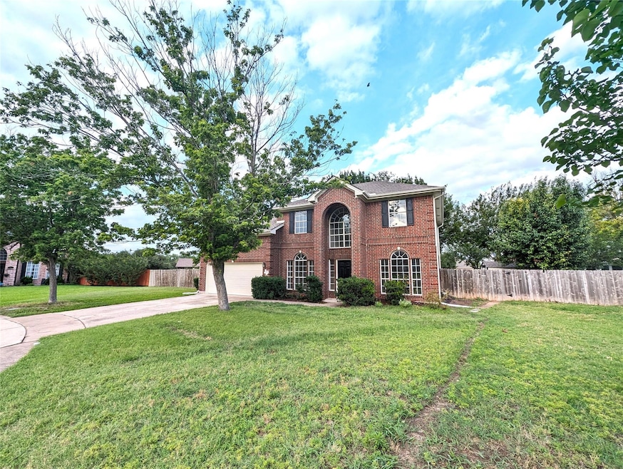 View of front facade with driveway and brick sidi