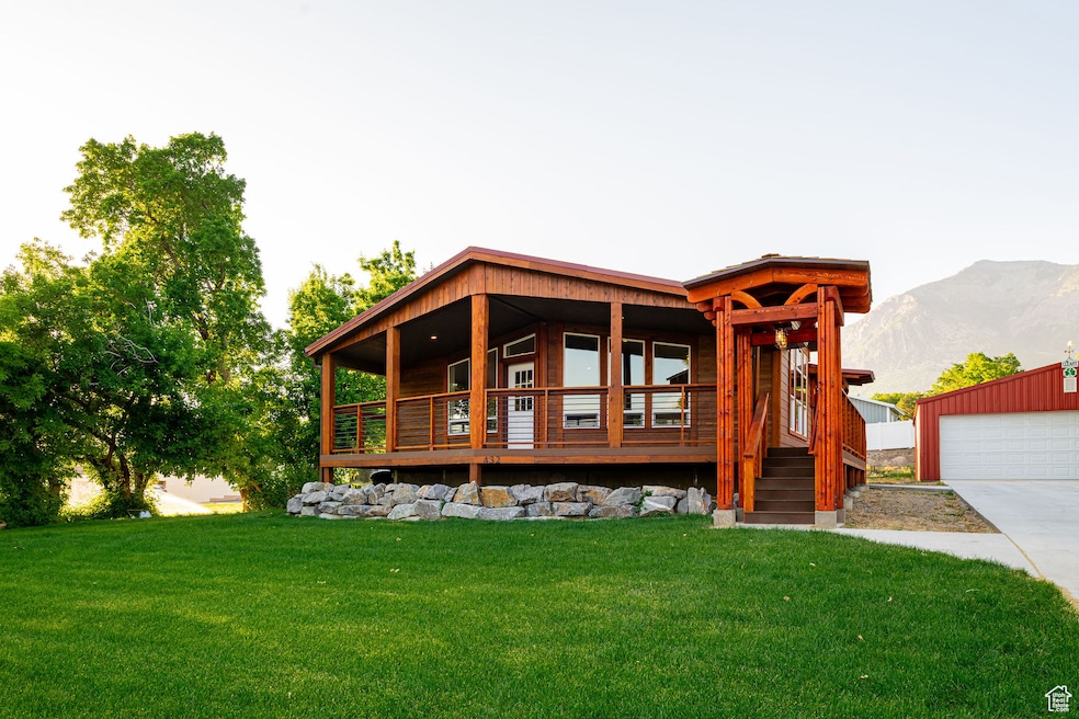 View of front of house featuring a front lawn, a mountain view, an outdoor structure, and a garage