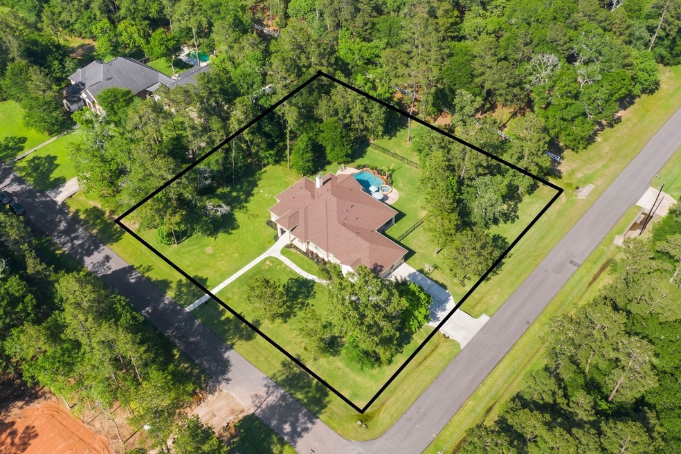 Welcome to the sprawling 1-story brick & stone home sitting on a corner lot of 1.15 acres in the gated community of Indigo Ranch in Magnolia.