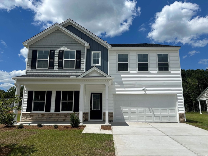View of front facade with a garage, covered porch,