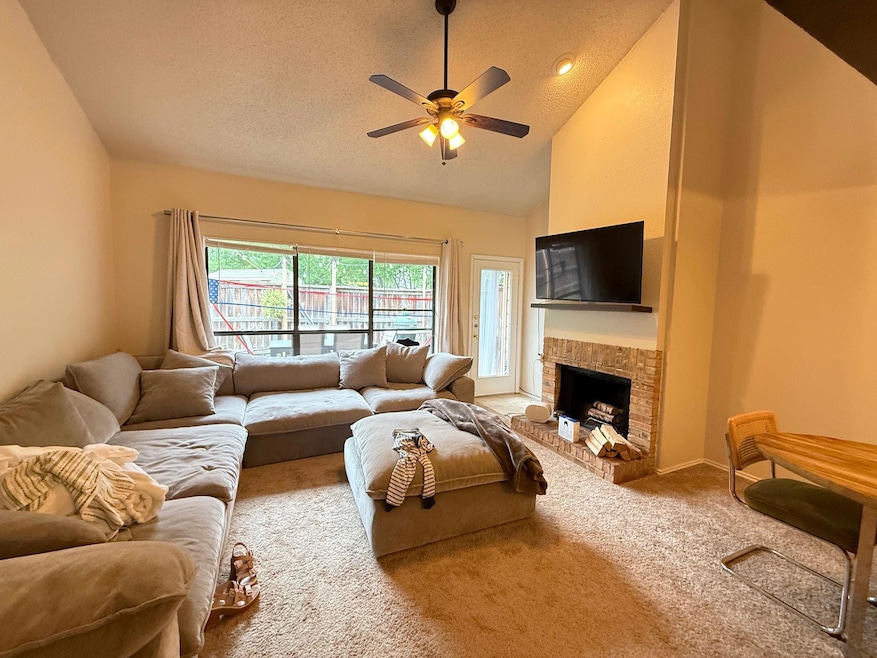 Living room with carpet floors, ceiling fan, a te