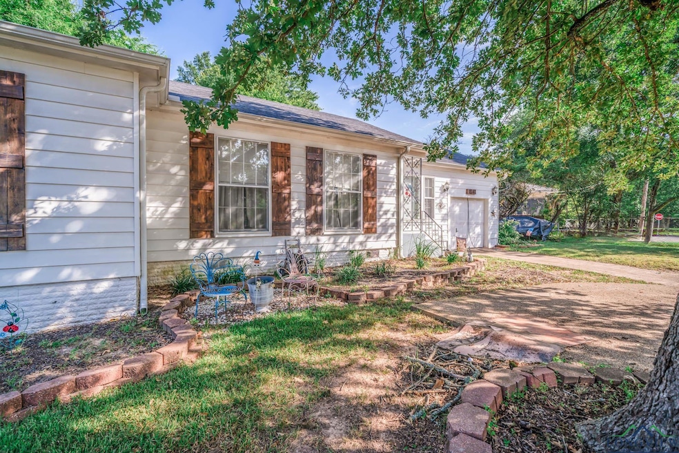 View of front of home featuring a garage and a front yard