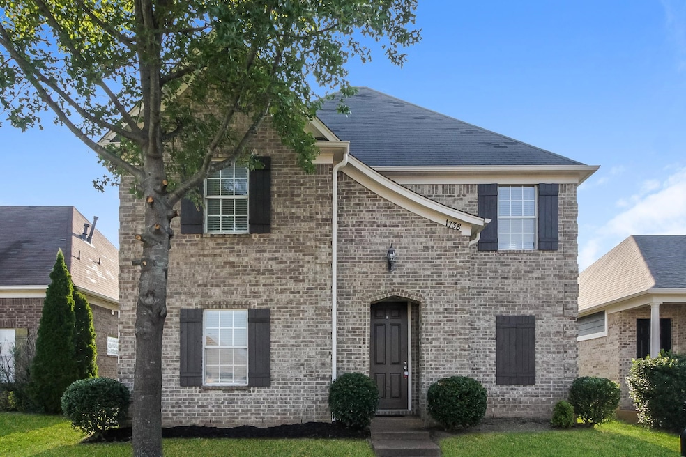 View of front of house featuring brick siding and a front lawn