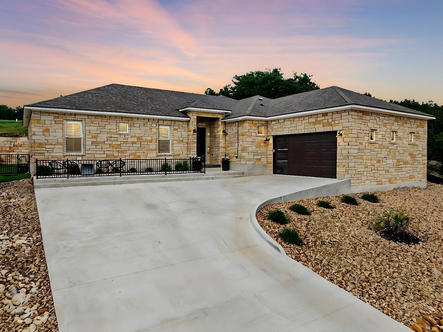 View of front of home featuring stone siding, con