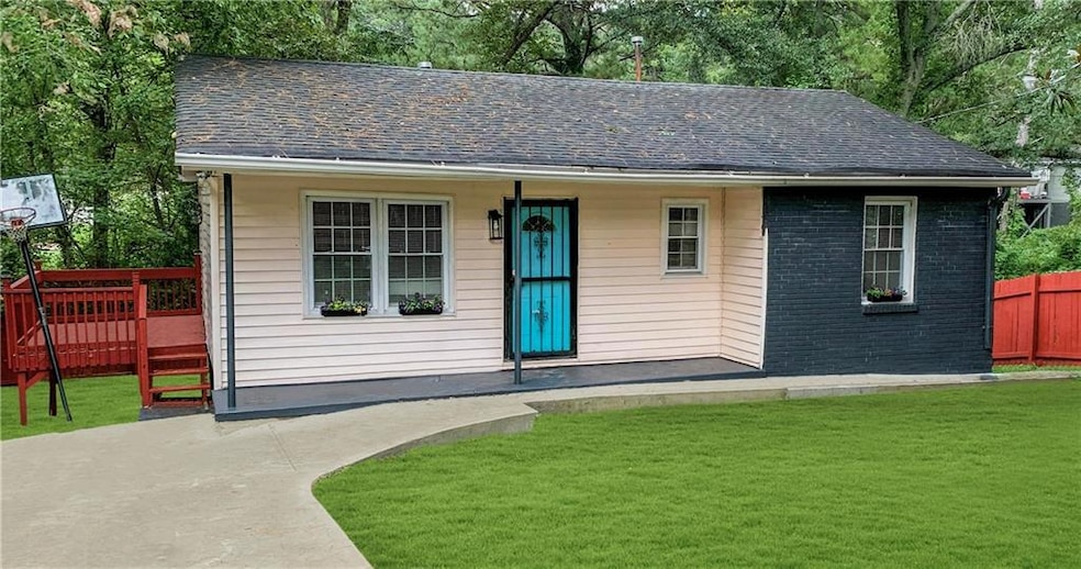 View of front facade with roof with shingles, brick siding, and a deck