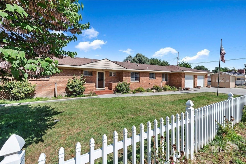 Ranch-style house featuring a fenced front yard, brick siding, driveway, and an attached garage