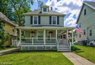 View of front facade featuring a front yard and a porch