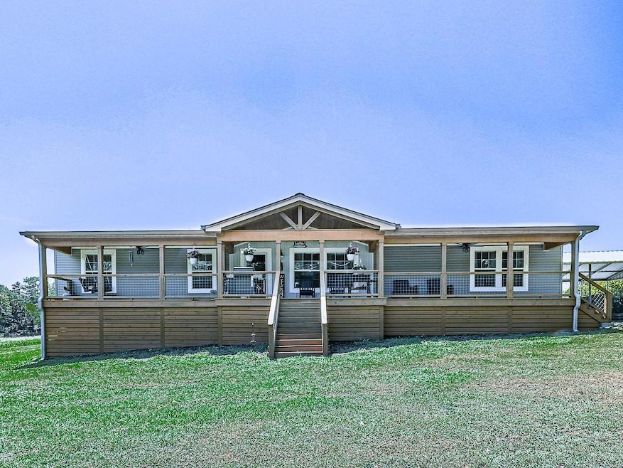 Rear view of property featuring stairway, covered porch, and a yard