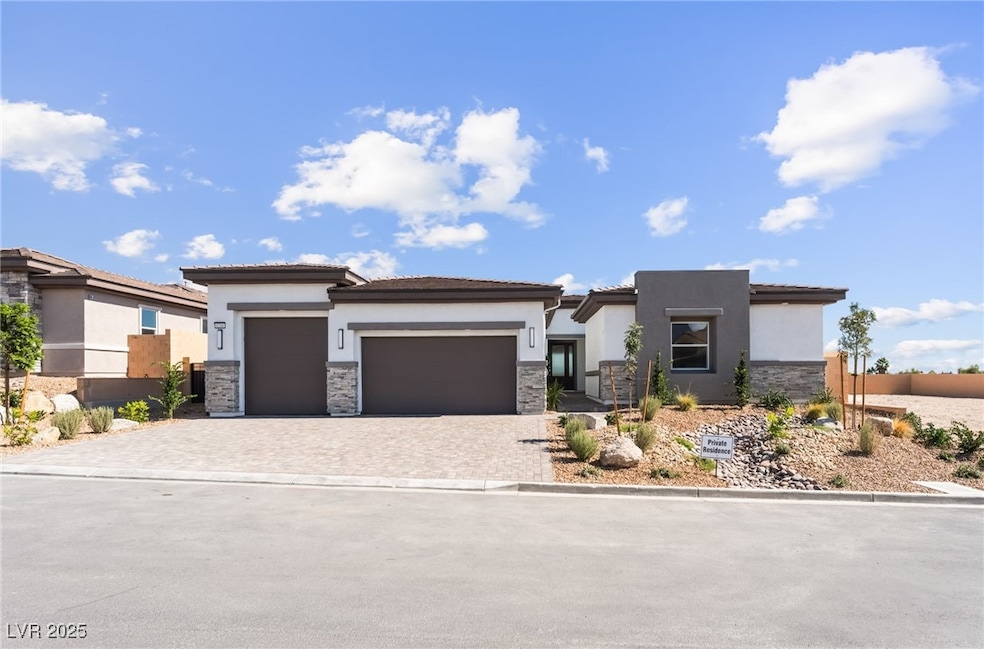 Prairie-style home with stone siding, stucco siding, a garage, decorative driveway, and a tiled roof