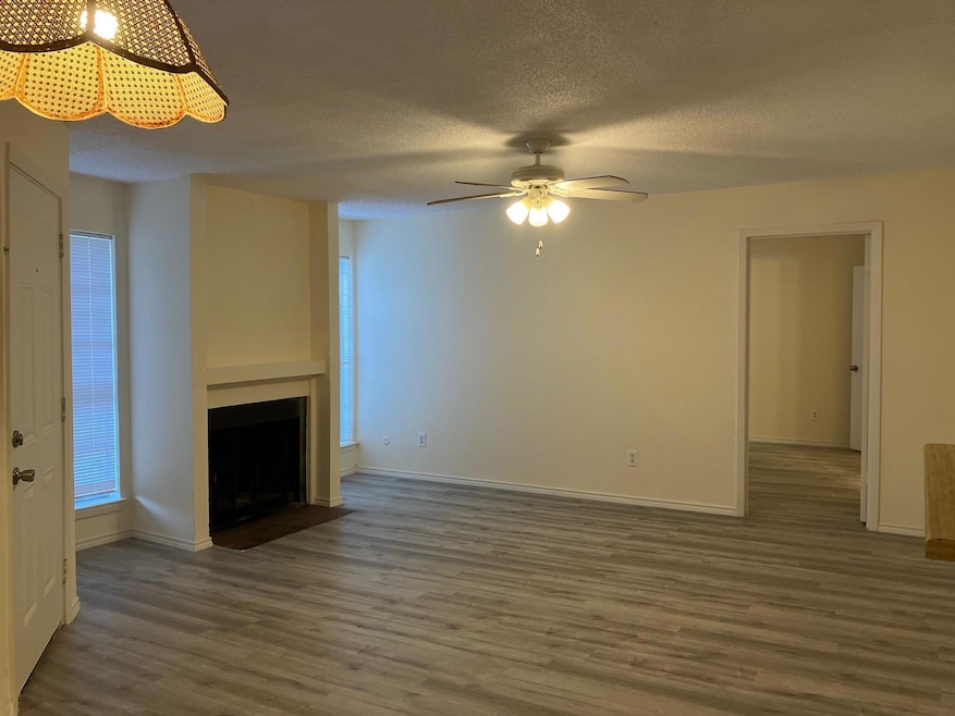Unfurnished living room with ceiling fan, dark har